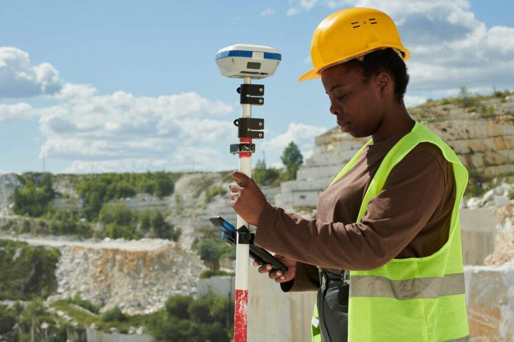 Young serious black woman in workwear adjusting technical equipment
